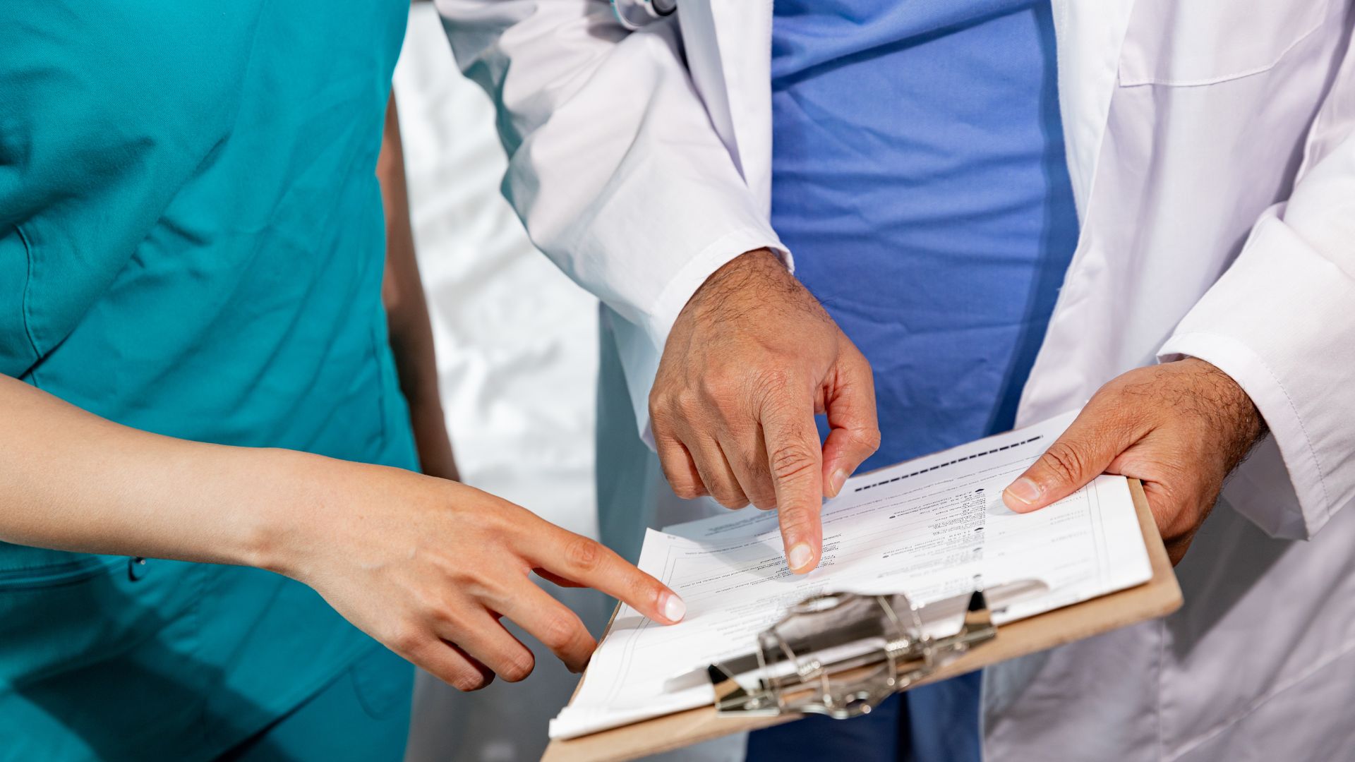 Medical professionals reviewing document together on clipboard