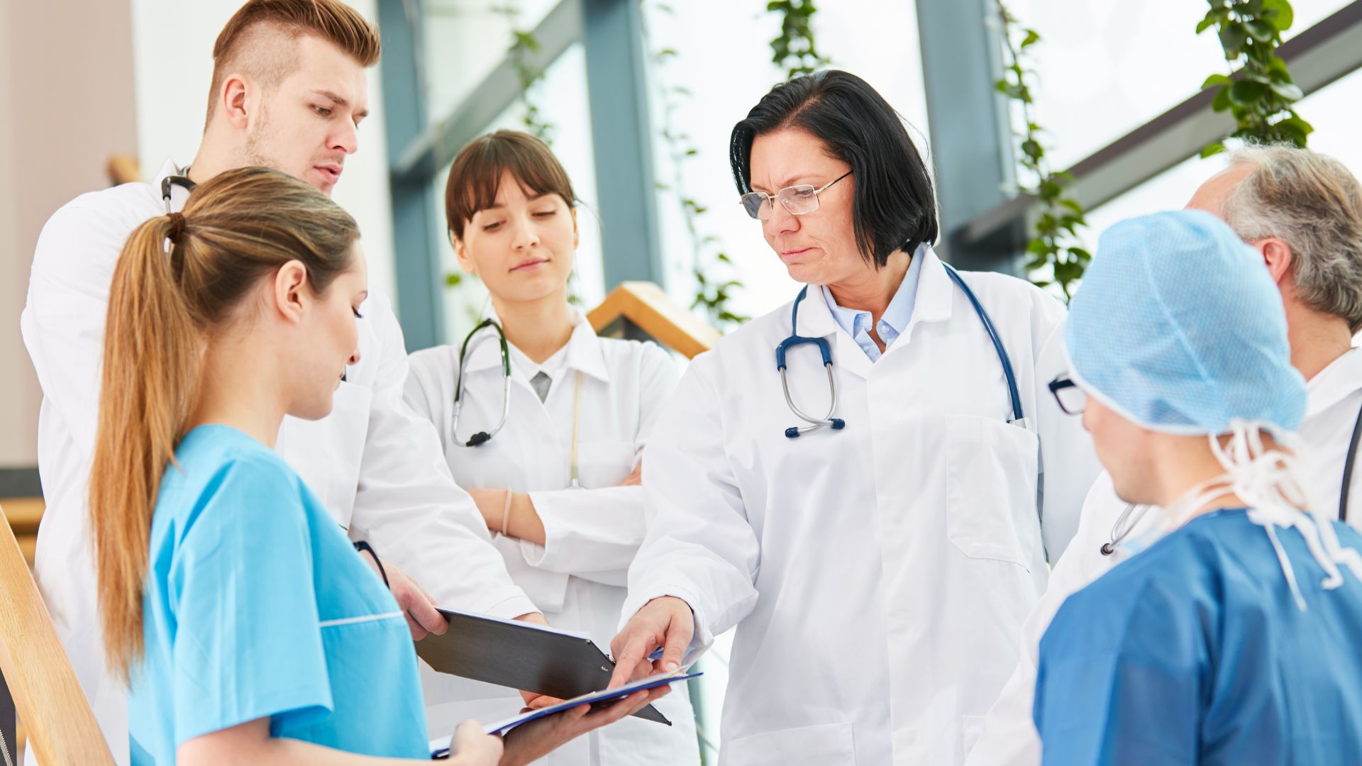 Medical team in white coats discussing patient case in hospital