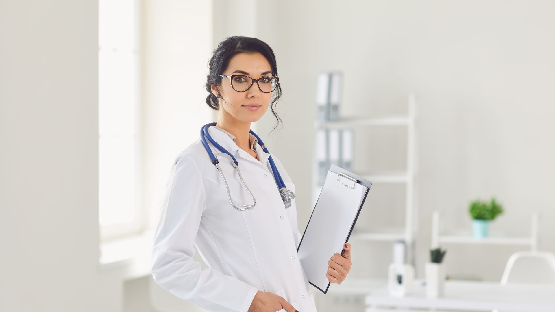 Medical professional in white coat with stethoscope holding clipboard